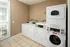On-site laundry facilities featuring multiple front-loading washers and dryers in a clean, tiled room with natural light from a large window at Abberly Woods Apartments in Charlotte, NC