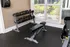 Free weights section of the fitness center featuring a rack of various dumbbells, an adjustable workout bench, large windows providing natural light, and rubber flooring for comfort at Abberly Woods Apartments in Charlotte, NC