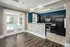 Clubhouse kitchen featuring a bar with a wood-paneled design, stainless steel appliances, dark cabinetry, and a view of the outdoor pool area through French doors at Abberly Woods Apartments in Charlotte, NCat Abberly Woods Apartments in Charlotte, NC