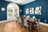 Clubhouse conference area featuring a large wooden table with modern chairs, contemporary artwork, and a large arched window providing ample natural light at Abberly Woods Apartments in Charlotte, NC