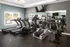 A room filled with lots of cardio equipment and a flat screen TV at Abberly Twin Hickory Apartments in Glen Allen, VA