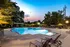 A swimming pool with lounge chairs and umbrellas at dusk at Abberly Twin Hickory Apartments in Glen Allen, VA