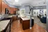 A demonstration kitchen with granite countertops and dark wood cabinets at Abberly Twin Hickory Apartments in Glen Allen, VA