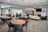 A common room with tables, chairs, and a fireplace at Abberly Twin Hickory Apartments in Glen Allen, VA
