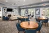 A resident clubhouse with tables, chairs, and a fireplace at Abberly Twin Hickory Apartments in Glen Allen, VA