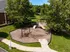 A playground with a slide and monkey bars in the middle of a grassy area at Abberly Twin Hickory Apartments in Glen Allen, VA