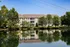A view of a pond with an apartment building in the background at Abberly Twin Hickory Apartments in Glen Allen, VA