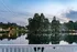 A view of a pond with a white railing in the foreground at Abberly Twin Hickory Apartments in Glen Allen, VA