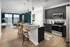 An open concept kitchen and living room with a large island with a granite countertop at Abberly Noda Vista Apartments in Charlotte, NC