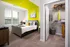 A bedroom with a green accent wall and gray carpet at Abberly Noda Vista Apartments in Charlotte, NC