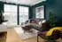 A living room with teal walls and a gray couch at Abberly Noda Vista Apartments in Charlotte, NC