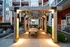 An outdoor patio with wicker furniture and a pergola at Abberly Noda Vista Apartments in Charlotte, NC