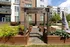 A courtyard with wood planters and a sculpture in front of an apartment building at Abberly Noda Vista Apartments in Charlotte, NC