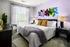 A bedroom with a large bed and a colorful painting on the wall at Abberly Noda Vista Apartments in Charlotte, NC