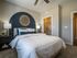 A bedroom featuring a bed and a prominent blue accent wall with large closet at Abberly Alston Apartments in Cary, NC