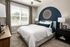 A bedroom featuring a bed and a prominent blue accent wall at Abberly Alston Apartments in Cary, NC