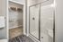 A modern bathroom featuring sleek fixtures, a walk-in shower, a sink, and a toilet. The space also includes a walk-in closet, providing ample storage and convenience at Abberly Alston Apartments in Cary, NC