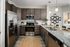 A modern kitchen with stainless steel appliances, including a refrigerator and oven. The countertops are made of polished granite at Abberly Alston Apartments in Cary, NC