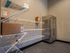 A package acceptance room featuring a wire shelf with neatly organized boxes and a refrigerator for storing perishable deliveries at Abberly Alston in Cary, NC at Abberly Alston Apartment Homes and Townhomes in Cary, NC