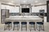 A demonstration kitchen featuring modern appliances and a spacious layout, with barstool seating at a counter at Abberly Alston Apartment Homes and Townhomes in Cary, NC