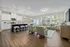 A living room with couches and chairs and a kitchen with a breakfast bar at Abberly Alston Townhomes in Cary, NC