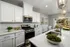 A kitchen with white cabinets and granite countertops at Abberly Alston Townhomes in Cary, NC
