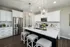A kitchen with white cabinets and granite countertops at Abberly Alston Townhomes in Cary, NC