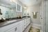 A bathroom featuring two sinks with modern fixtures, and large mirrors above the sinks at Abberly Alston Townhomes in Cary, NC