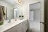 A bathroom with modern fixtures, a large mirror above the sink at Abberly Alston Townhomes in Cary, NC