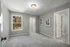 A bedroom with gray walls, carpet flooring, window for natural lighting and a cozy atmosphere at Abberly Alston Townhomes in Cary, NC