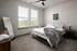 Comfortable bedroom featuring a bed and two windows at Abberly Foundry Apartments in Nashville, TN