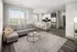 Cozy living room featuring a couch, a table, and a kitchen in the background at Abberly Foundry Apartments in Nashville, TN