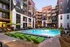 Swimming pool area featuring green lounge chairs in front of an apartment building at Abberly Foundry Apartments in Nashville, TN