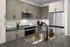 Modern kitchen featuring gray cabinets and a stainless steel sink at Abberly Foundry Apartments in Nashville, TN