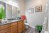 Spacious bathroom vanity and mirror with plank flooring and a walk-in closet at Abberly Crest Apartments in Lexington Park, MD