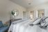 Cozy bedroom with a large bed and a blue chair at Abberly Crest Apartments in Lexington Park, MD