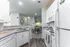 Kitchen with white cabinets, white appliances, and luxury plank flooring at Abberly Crest Apartments in Lexington Park, MD