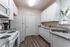 Kitchen with white cabinets, white appliances, and luxury plank flooring at Abberly Crest Apartments in Lexington Park, MD