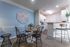 Dining area with a small table and chairs and a kitchen in the background at Abberly Crest Apartments in Lexington Park, MD