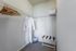 Walk-in closet with a white robe and wooden hangers at Abberly Crest Apartments in Lexington Park, MD
