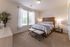 Cozy bedroom with a bed and two windows, modern apartment, luxury living, and spacious layout at Abberly Crest Apartments in Lexington Park, MD