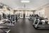 Room filled with lots of cardio equipment and weights at Abberly Crest Apartments in Lexington Park, MD