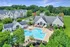Aerial view of a luxurious resort pool with lounge chairs and umbrellas at Abberly Crest Apartments in Lexington Park, MD
