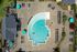 Aerial view of a luxurious resort pool with lounge chairs and umbrellas at Abberly Crest Apartments in Lexington Park, MD