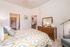 Cozy bedroom with a bed and a dresser with a mirror at Abberly Crest Apartments in Lexington Park, MD