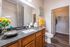 Spacious bathroom vanity and mirror with plank flooring and a walk-in closet at Abberly Crest Apartments in Lexington Park, MD