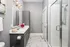 A modern style bathroom with walk in shower and large vanity with mirror at Abberly Onyx Apartments in Decatur, GA