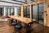 A stylish room featuring a long wooden table with black stools and glass doors at Abberly Foundry Apartment Homes in Nashville, Tennessee