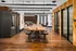 A modern conference room featuring a long wooden table and black stools at Abberly Foundry Apartment Homes in Nashville, TN