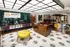 A view of the Abberly Foundry reception desk featuring purple and green chairs and a yellow accent at Abberly Foundry Apartment Homes in Nashville, TN